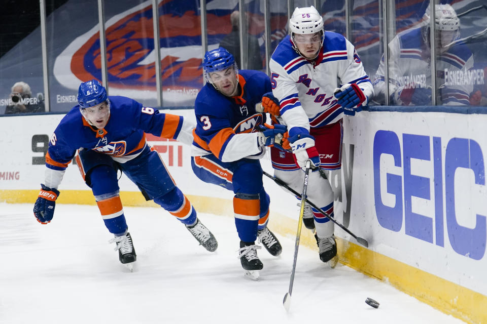 New York Rangers' Ryan Lindgren, right, vies for control of the puck against New York Islanders' Adam Pelech (3) and Ryan Pulock (6) during the first period of an NHL hockey game Tuesday, April 20, 2021, in Uniondale, N.Y. (AP Photo/Frank Franklin II)