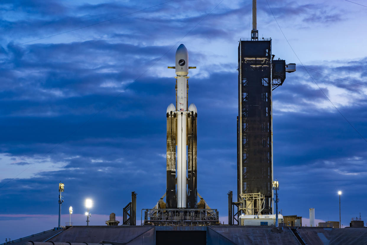  A SpaceX Falcon Heavy rocket on the launch pad with clouds in the background for the X-37B OTV-7 mission. 