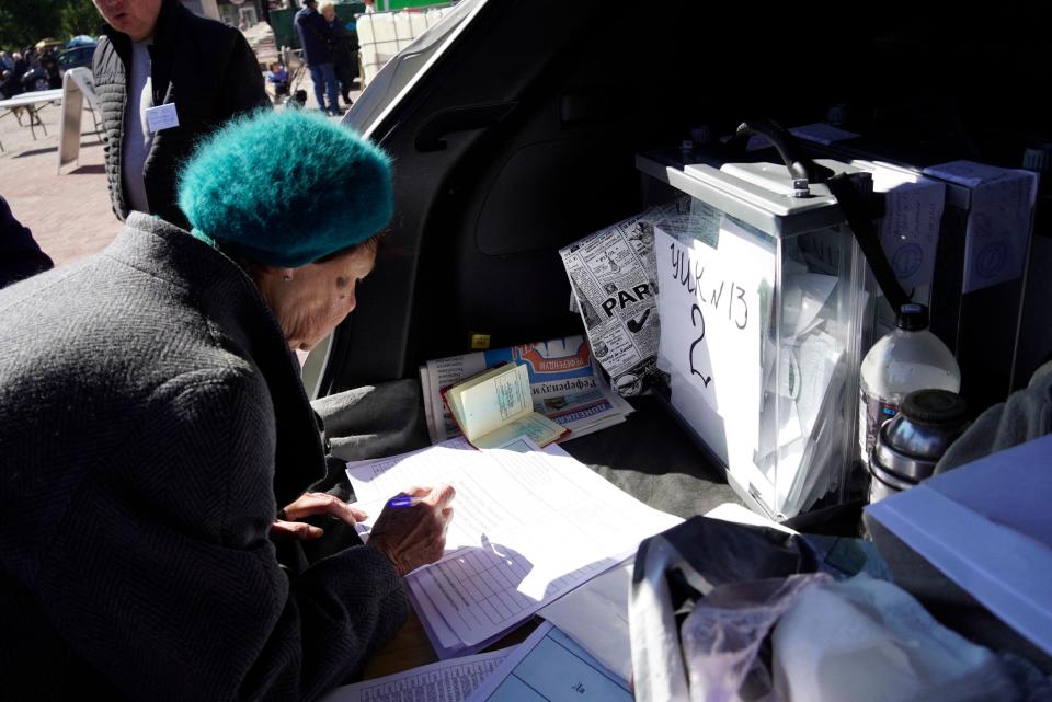 A woman attends a referendum at a mobile voting station in Mariupol on September 25, 2022.