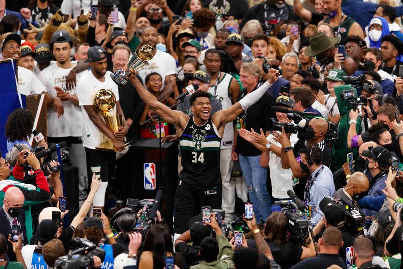 El alero de los Milwaukee Bucks Giannis Antetokounmpo (34) celebra con el trofeo de MVP de las Finales de la NBA tras el partido contra los Phoenix Suns