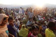 FILE PHOTO: The sun rises as thousands of Rohingya refugees who fled from Myanmar a day before wait by the road where they spent the night between refugee camps, near Cox's Bazar, Bangladesh October 10, 2017. REUTERS/Damir Sagolj/File Photo