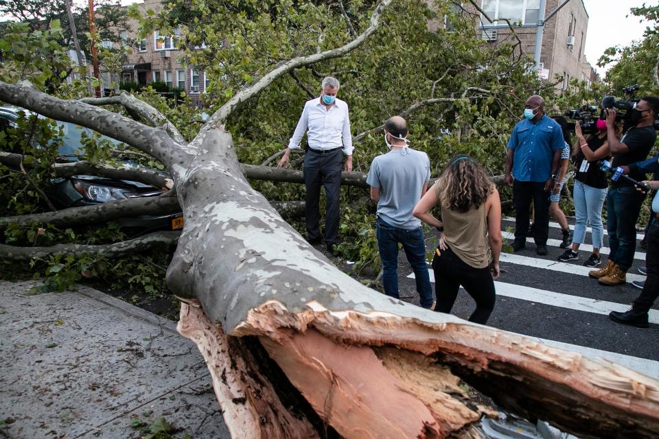 New York City Mayor Bill de Blasio talks with residents about damage from Tropical Storm Isaias, Tuesday, Aug. 4, 2020, in the Queens borough of New York. (AP Photo/Frank Franklin II)