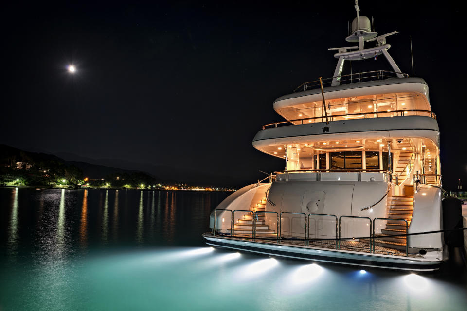 Luxury yacht in marina at night.
