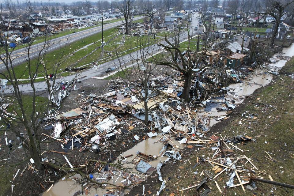 Debris scatters the ground near damaged homes following a severe storm Friday, March 15, 2024, in Lakeview, Ohio. (AP Photo/Joshua A. Bickel)