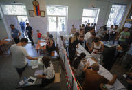 People at a polling station during a parliamentary election in Yerevan, Armenia, Sunday, June 20, 2021. Armenians are voting in a national election after months of tensions over last year's defeat in fighting against Azerbaijan over the separatist region of Nagorno-Karabakh. (AP Photo/Sergei Grits)