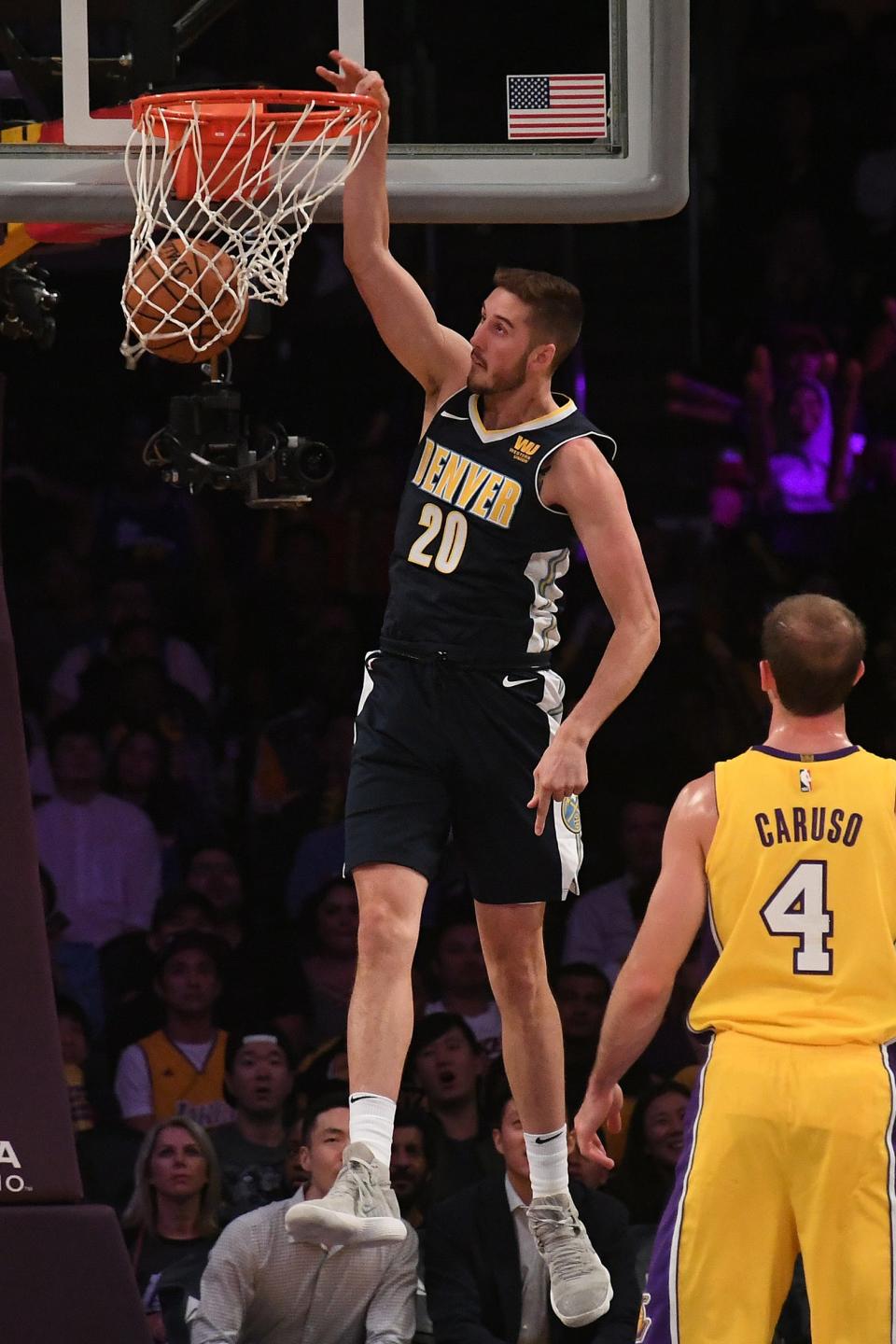 Denver Nuggets forward Tyler Lydon dunks the ball in front of Los Angeles Lakers guard Alex Caruso on Oct. 2, 2017 in Los Angeles.