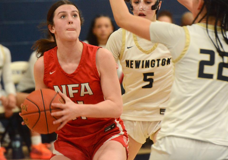 NFA freshman Sese Atchinson goes up for a shot against Newington defenders Hope Romanello (5) and Bela Cucuta (22) in Monday's Class LL quarterfinal at Newington High School.