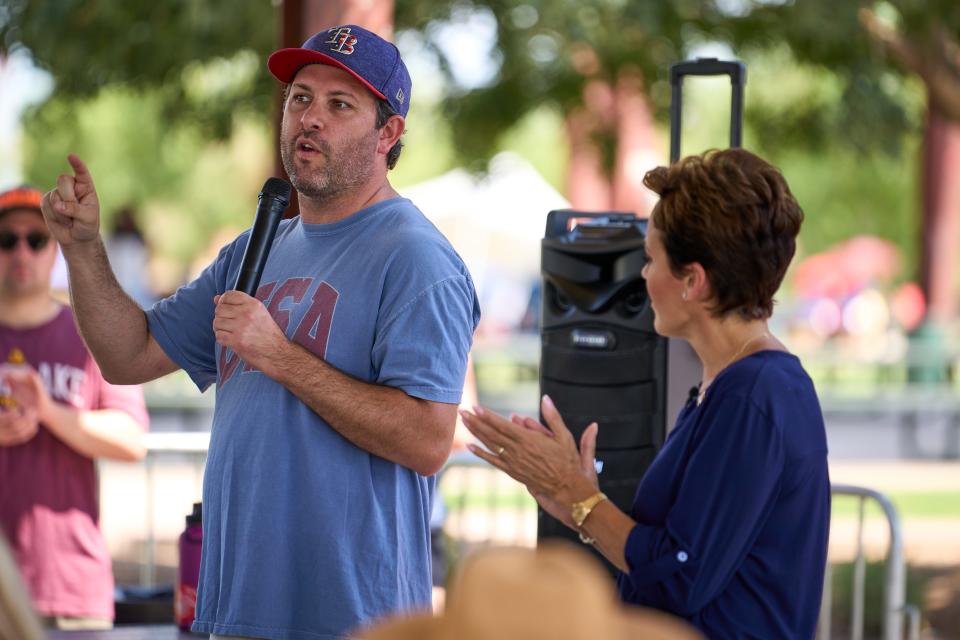 Tyler Bowyer, chief operating officer of Turning Point Action, speaks while gubernatorial candidate Kari Lake applauds during the Turning Point Action event at South Mountain Pavilion at Tumbleweed Park in Chandler on Aug. 27, 2022.