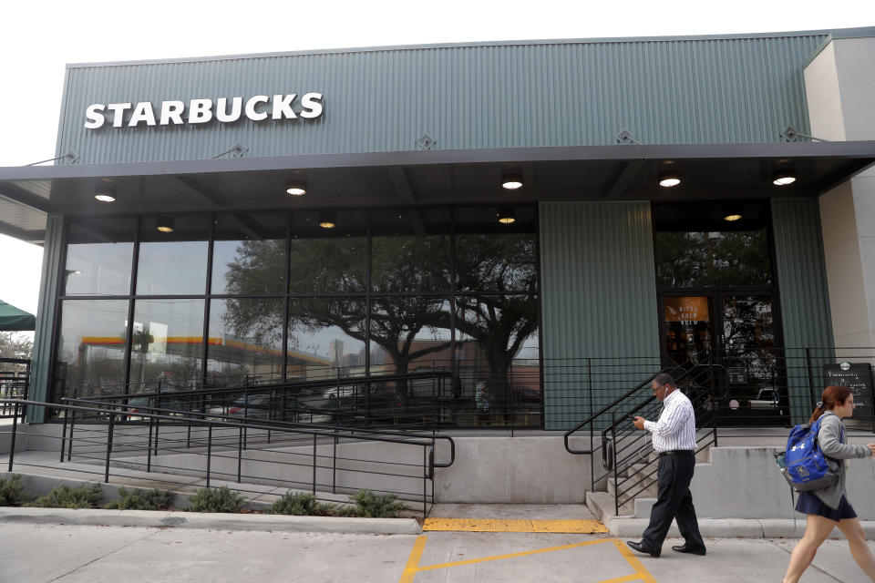 Customers come and go at a Starbucks on South Claiborne Ave. in New Orleans, Thursday, Jan. 16, 2020. Starbucks, the home of the $4 latte, is expanding a program to open coffee shops in poor neighborhoods. The Seattle-based company plans to open or remodel 85 stores by 2025 in rural and urban communities across the U.S. Each store will have event space, and Starbucks will work with local United Way chapters to offer programs like youth job training. (AP Photo/Gerald Herbert)