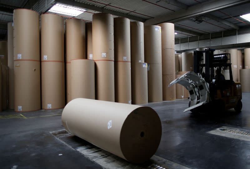 FILE PHOTO: An employee transports a giant reel of paper inside the carboard box manufacturing company DS Smith Packaging Atlantique in La Chevroliere