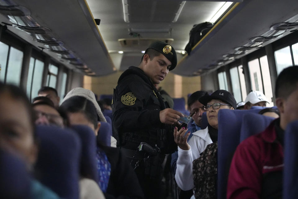 Un agente de policía revisa las identificaciones de los pasajeros de autobús en un punto de control de contrabando en Pucusana, Perú, el lunes 17 de julio de 2023. La policía también verifica si los pasajeros llevan armas en el bus que viaja hacia la capital desde el interior del país, con miras a la manifestación del 19 de julio contra el gobierno. (AP Foto/Guadalupe Pardo)