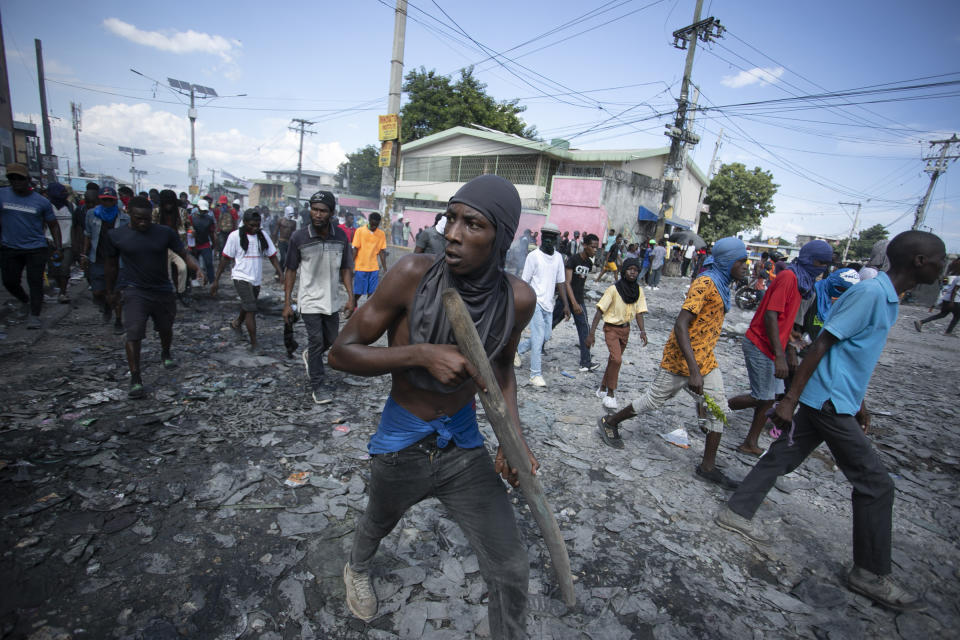 Un manifestante lleva un trozo de madera que simula un arma durante una protesta en la que se exigió la renuncia del primer ministro Ariel Henry en el área de Petion-Ville de Puerto Príncipe, Haití, el 3 de octubre de 2022. (AP Foto/Odelyn Joseph)