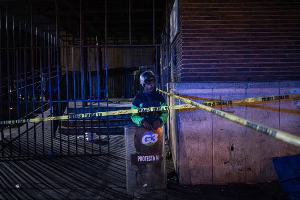 A private security guard stands at the scene of a fire in Johannesburg on 31 August 2023 (AFP via Getty Images)