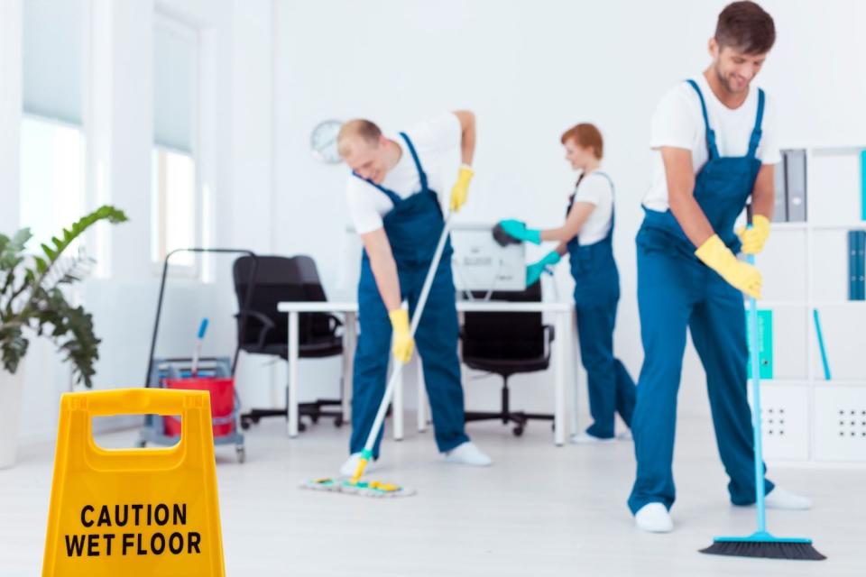 A team of cleaners mop floors.