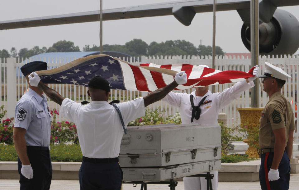 U.S. military personnel drape the U.S. national flag over a coffin containing possible remains of a U.S. serviceman during a repatriation ceremony at Phnom Penh International Airport, Cambodia, Wednesday, April 2, 2014. The possible remains of U.S. soldiers found in eastern Kampong Cham province were repatriated to Hawaii for testing. (AP Photo/Heng Sinith)