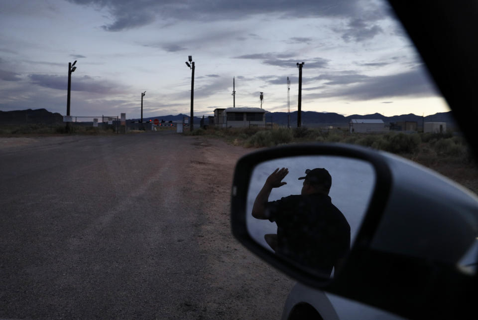 In this July 22, 2019 photo, Terris Williams, reflected in a mirror, visits an entrance to the Nevada Test and Training Range near Area 51 outside of Rachel, Nev. The U.S. Air Force has warned people against participating in an internet joke suggesting a large crowd of people "storm Area 51," the top-secret Cold War test site in the Nevada desert. (AP Photo/John Locher)