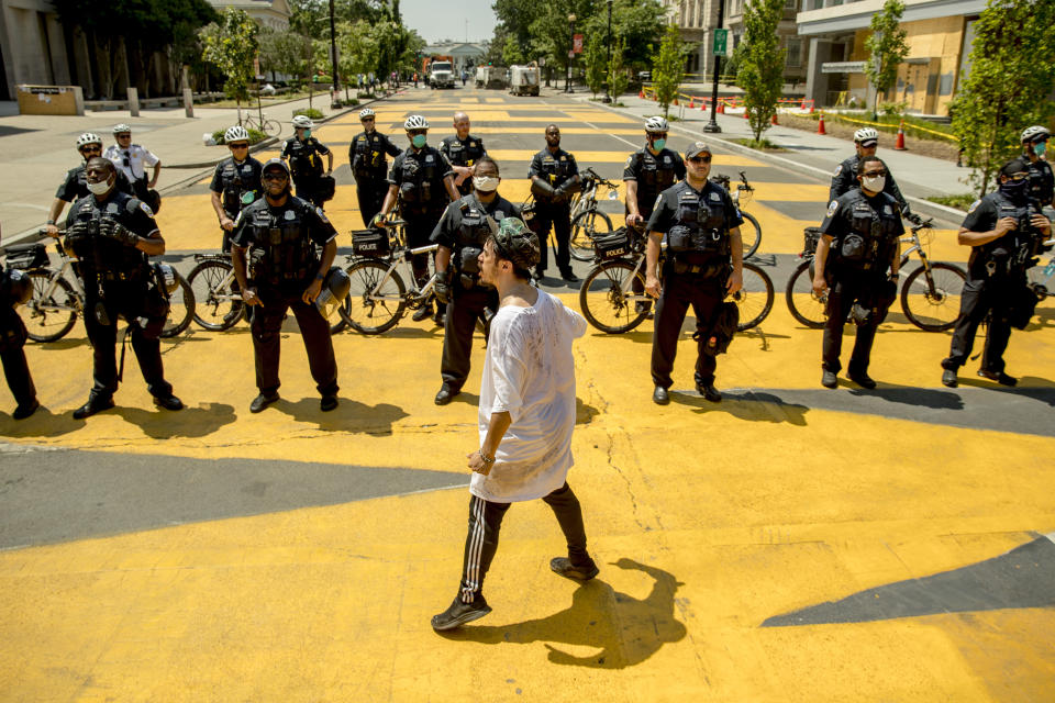 FILE - In this June 23, 2020, file photo a man shouts at a line of police officers after they closed 16th Street Northwest between H and I Street, renamed Black Lives Matter Plaza in Washington. In the early days of the protests, District of Columbia Mayor Muriel Bowser publicly sided with the demonstrators as Trump usurped local authority and called in a massive federal security response. Bowser responded by renaming the protest epicenter, within sight of the White House, as Black Lives Matter Plaza. (AP Photo/Andrew Harnik, File)