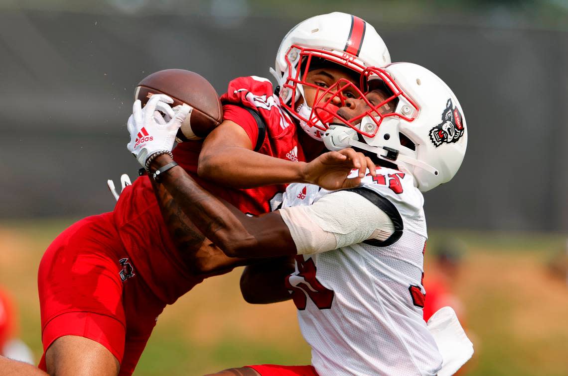 N.C. State wide receiver Christopher Scott Jr. (35) fights to pull in a pass as N.C. State safety Daemon Fagan (20) defends during the Wolfpack’s first fall practice in Raleigh, N.C., Wednesday, August 2, 2023. Ethan Hyman/ehyman@newsobserver.com