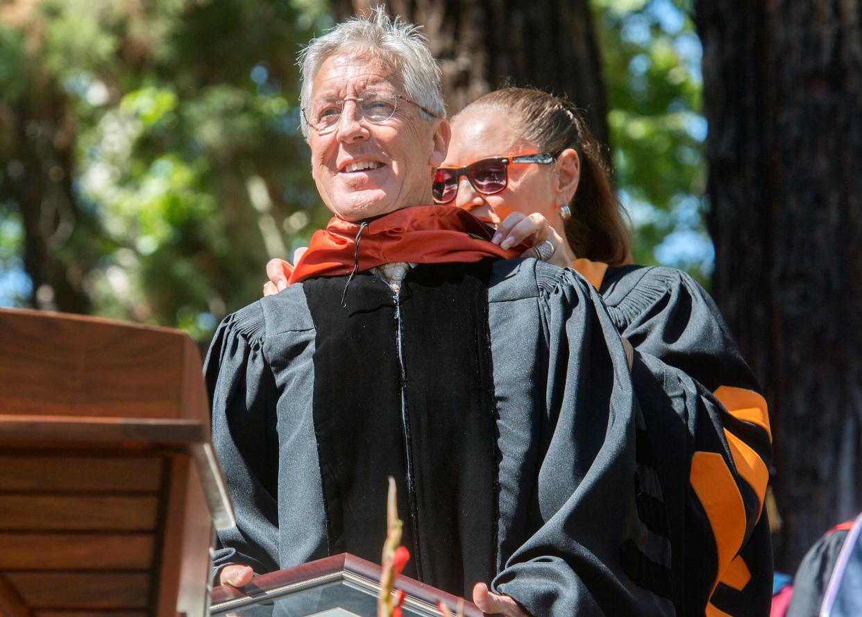 Seattle Seahawks head coach Pete Carroll has a sash place on him by University of the Pacific regent Mary-Elizabeth Eberhardt after he received an honorary MBA degree during the 2022 commencement ceremonies at Pacific's Knoles Lawn in Stockton.