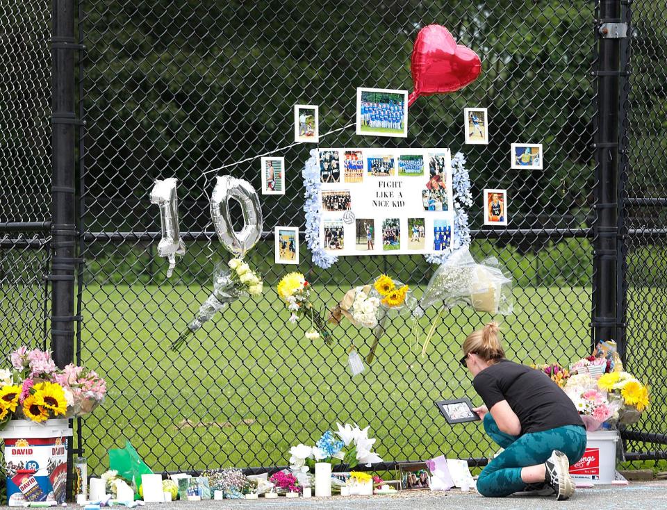 Fiona Santoro, of Quincy, pays her respects on Tuesday June 20, 2023, at a memorial for Priscilla Bonica, who died recently after a two-year battle with brain cancer. Fiona's daughter Cinneide played youth softball with Bonica at Mitchell/McCoy Field, the site of the memorial.
