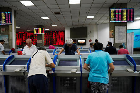 Investors look at computer screens showing stock information at a brokerage house in Shanghai, China September 7, 2018. REUTERS/Aly Song