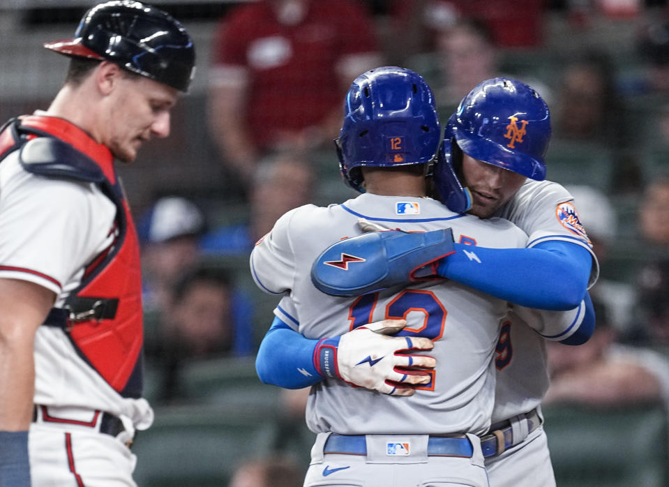 New York Mets' Francisco Lindor (12) hugs teammate Brandon Nimmo (9) after hitting a three-run home run as Atlanta Braves catcher Sean Murphy (12) looks on in the sixth inning of a baseball game Monday, Aug. 21, 2023, in Atlanta. (AP Photo/John Bazemore)