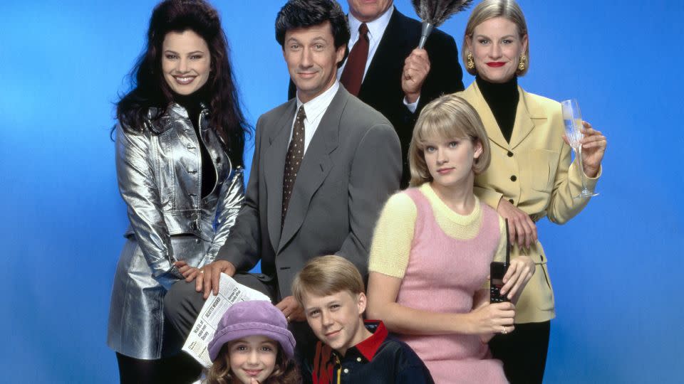 Drescher in character as Fran Fine in a promotional photo for "The Nanny", pictured with the show's other principcal cast members. From left: Drescher, Charles Shaughnessy (as Maxwell Sheffield), Daniel Davis (as Niles) and Lauren Lane (as C.C. Babcock). Seated in front. from left. are Madeline Zima (as Grace Sheffield), Benjamin Salisbury (as Brighton Sheffield) and Nicholle Tom (as Maggie Sheffield). - CBS/Getty Images