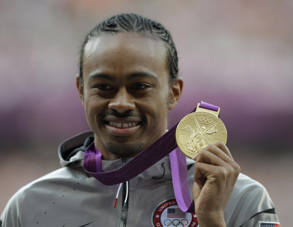 FILE - United States' gold medal winner Aries Merritt shows off his medal during the ceremony for the men's 110-meter hurdles at the athletics in the Olympic Stadium at the 2012 Summer Olympics, London, Thursday, Aug. 9, 2012. Top hurdlers reach out to world-record holder Aries Merritt to ask for his input all the time. So do those going through transplants. Merritt had a kidney transplant in 2015, just days after winning a bronze medal at the Beijing world championships. (AP Photo/Matt Slocum, File)