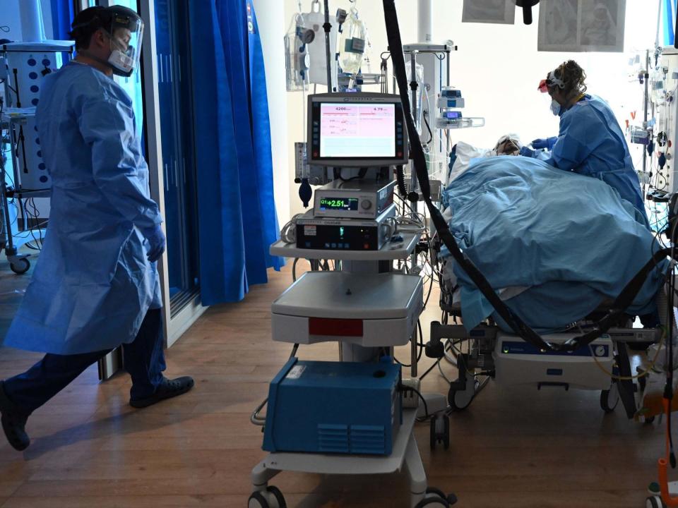 Clinical staff wear personal protective equipment (PPE) as they care for a patient at the intensive care unit at the Royal Papworth Hospital in Cambridge, 5 May 2020: Neil Hall/PA