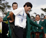 Defending Masters' champion Adam Scott, of Australia, helps Bubba Watson, right, with his green jacket after winning the Masters golf tournament Sunday, April 13, 2014, in Augusta, Ga. (AP Photo/Matt Slocum)