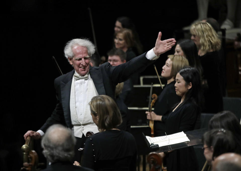 In this Feb. 14, 2019 photo, conductor Benjamin Zander gestures to members of the Boston Philharmonic Orchestra at the Sanders Theatre in Cambridge, Mass. The internationally acclaimed conductor, who approaches his 80th birthday on March 9, has spent half his life leading the Boston Philharmonic Orchestra, which he founded in 1979. (AP Photo/Elise Amendola)