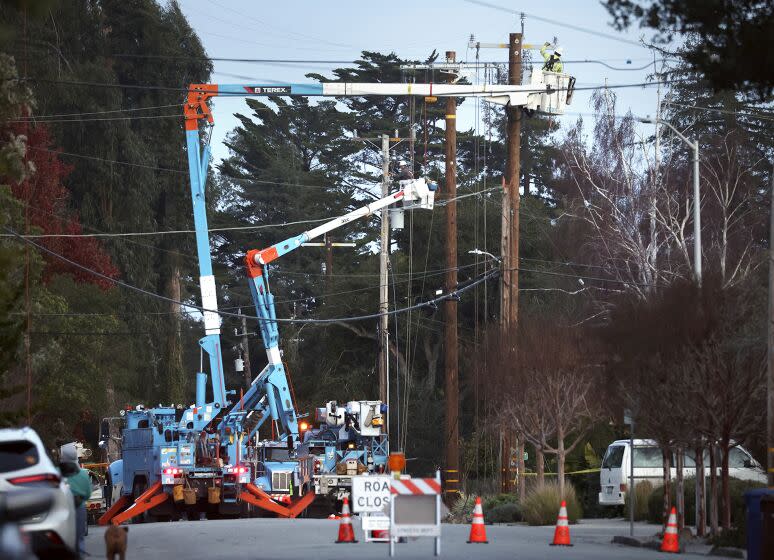 PG&E workers toil in the evening above Highland Avenue to replace equipment damaged by high winds in Santa Cruz, Calif., Tuesday, Jan. 10, 2023. (Shmuel Thaler/The Santa Cruz Sentinel via AP)