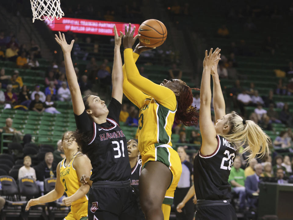 Baylor guard Aijha Blackwell, center, attempts a basket between Harvard forward Katie Krupa, left, and guard Lola Mullaney, right, in the first half of an NCAA college basketball game, Sunday, Nov. 19, 2023, in Waco, Texas. (Rod Aydelotte/Waco Tribune-Herald via AP)