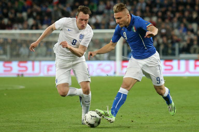 England's defender Phil Jones (L) fights for the ball with Italy's forward Ciro Immobile during the friendly football match on March 31, 2015 in Turin