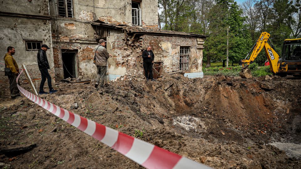 Utility workers clean up the aftermath of an overnight Russian rocket attack in the Ukrainian city of Kharkiv on April 27. - Stringer/Anadolu via Getty Images