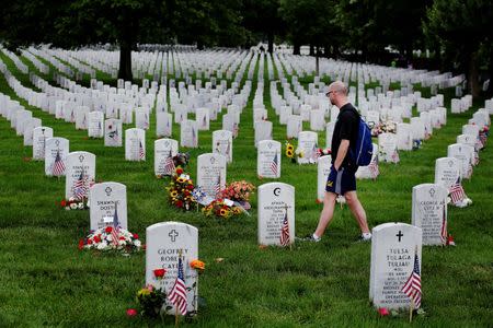 A mourner walks past the grave marker of U.S. Army Staff Sergeant Ayman Taha inside of Section 60 in Arlington National Cemetery on Memorial Day, May 30, 2016. REUTERS/Lucas Jackson