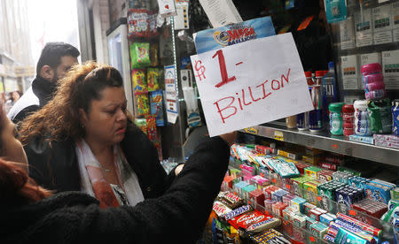 An impromptu "One Billion dollars" sign is on display as customers line up to buy Mega Millions tickets at a newsstand in midtown Manhattan in New York, U.S., October 19, 2018. REUTERS/Mike Sugar