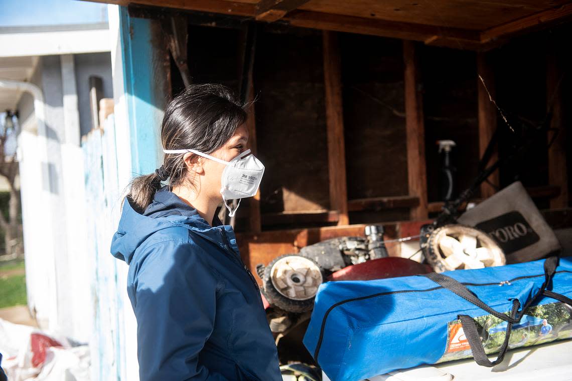 Isabel Ramirez, 24, looks at items damaged by floodwater in a garage at her home in Planada, Calif., on Thursday, Jan. 12, 2023. Ramirez recently returned to her home after the Merced County Sheriff’s Office downgraded an evacuation order to a warning.