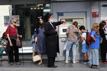 An ultra-Orthodox Jewish man looks at his watch as he stands near tracks of the light rail in Jerusalem October 18, 2018. REUTERS/Ammar Awad