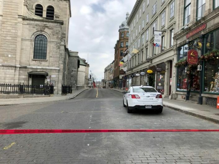Police cars close off a street in Old Quebecafter a sword-wielding attacker dressed in medieval costume killed two people and injured five others