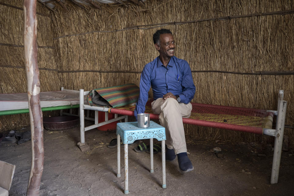 Surgeon and doctor-turned-refugee, Dr. Tewodros Tefera, takes a cigarette break inside his shelter at the Sudanese Red Crescent clinic where he works, in Hamdayet, eastern Sudan, near the border with Ethiopia, on March 22, 2021. (AP Photo/Nariman El-Mofty)