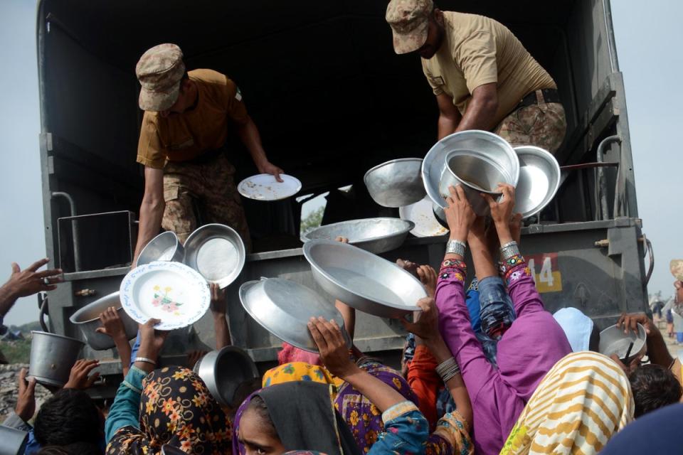 Pakistani army soldiers distribute food to flood-affected people in Rajanpur, Punjab province on Saturday (EPA)