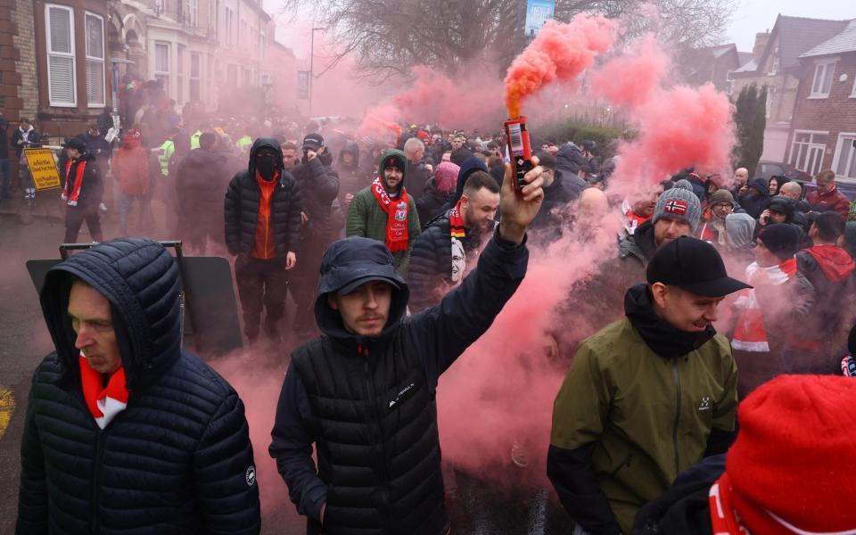 Liverpool fans lets off smoke flares as they walk to the stadium before the match