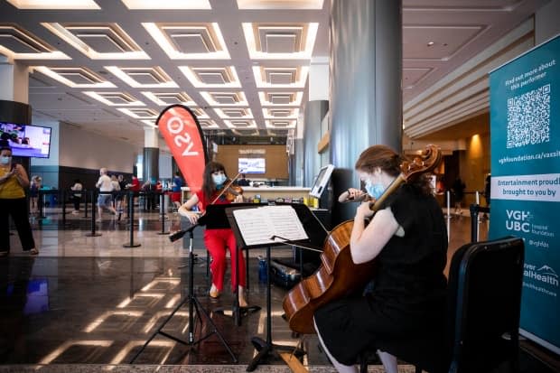 Members of the Vancouver Symphony Orchestra perform for people at the COVID-19 vaccination clinic at the Vancouver Convention Centre on June 24.  (Ben Nelms/CBC - image credit)