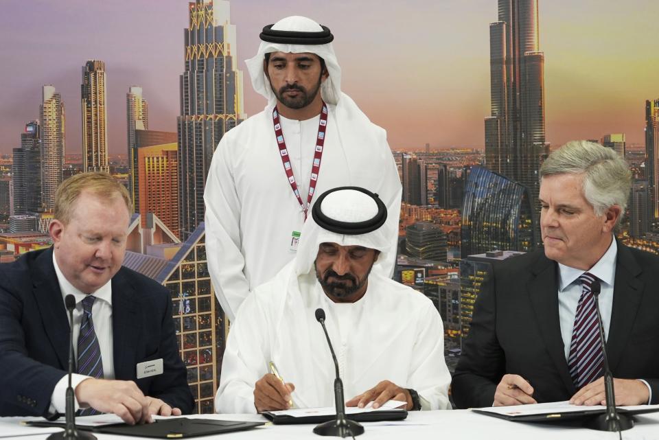 From left, Boeing Co. Vice President Stan Deal, Emirates CEO and Chairman Sheikh Ahmed bin Saeed Al Maktoum and General Electric Co. CEO Lawrence Culp Jr. sign a $52 billion deal by Emirates to purchase Boeing aircraft with GE engines, at the Dubai Air Show, in Dubai, United Arab Emirates, Monday, Nov. 13, 2023 . Dubai Crown Prince Sheikh Hamdan bin Mohammed Al Maktoum watches from behind them. Long-haul carrier Emirates opened the Dubai Air Show with a $52 billion purchase of Boeing Co. aircraft, showing how aviation has bounced back after the groundings of the coronavirus pandemic, even as Israel's war with Hamas clouds regional security. (AP Photo/Lujain Jo)