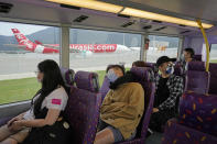 Passengers sit on the upper deck of a double-decker bus during a tour in Hong Kong, Saturday, Oct. 16, 2021. Travel-starved, sleep-deprived residents might find a new Hong Kong bus tour to be a snooze. The 76-kilometer (47-mile), five-hour ride on a regular double-decker bus around the territory is meant to appeal to people who are easily lulled asleep by long rides. It was inspired by the tendency of tired commuters to fall asleep on public transit. (AP Photo/Kin Cheung)