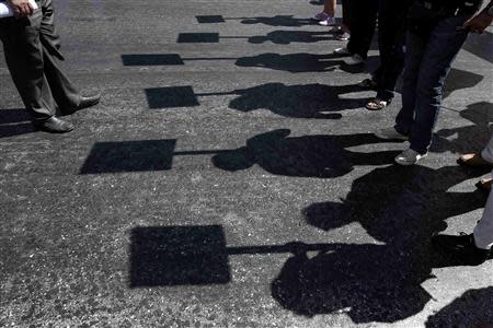 Protesters holding banners cast their shadows as they march during an anti-government rally in front of the parliament in Athens September 18, 2013. REUTERS/Yorgos Karahalis