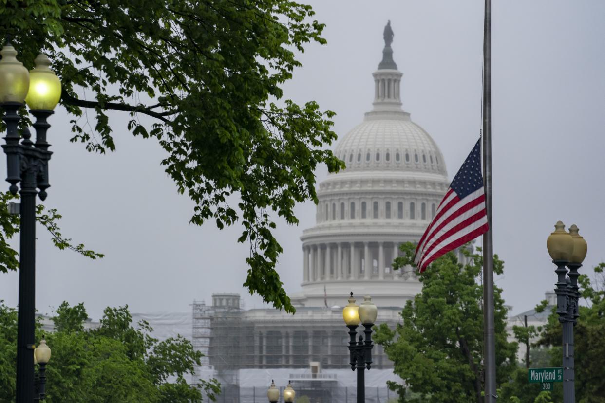 The American flag is seen at half-staff with the Capitol in the distance, in Washington, Friday, May 13, 2022. President Joe Biden ordered the flags lowered on all Federal buildings to honor the nearly 1 million deaths in America due to the COVID-19 outbreak. 