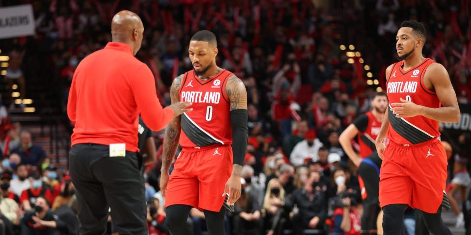 Chauncey Billups talks to Damian Lillard and CJ McCollum as they walk off the court.