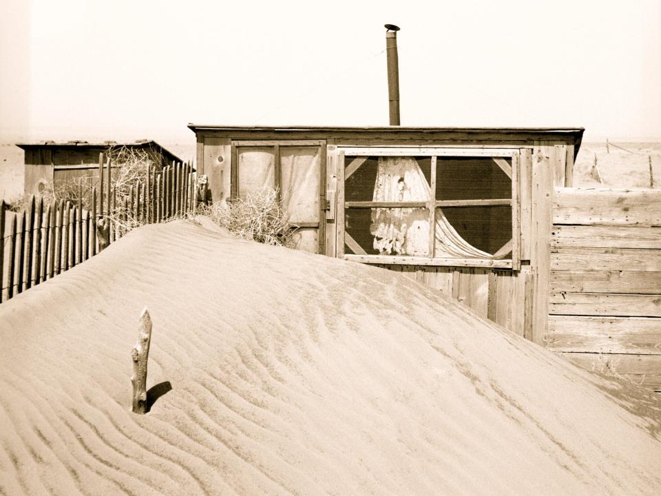 Sand piled up in front of a farm in Oklahoma in 1936.